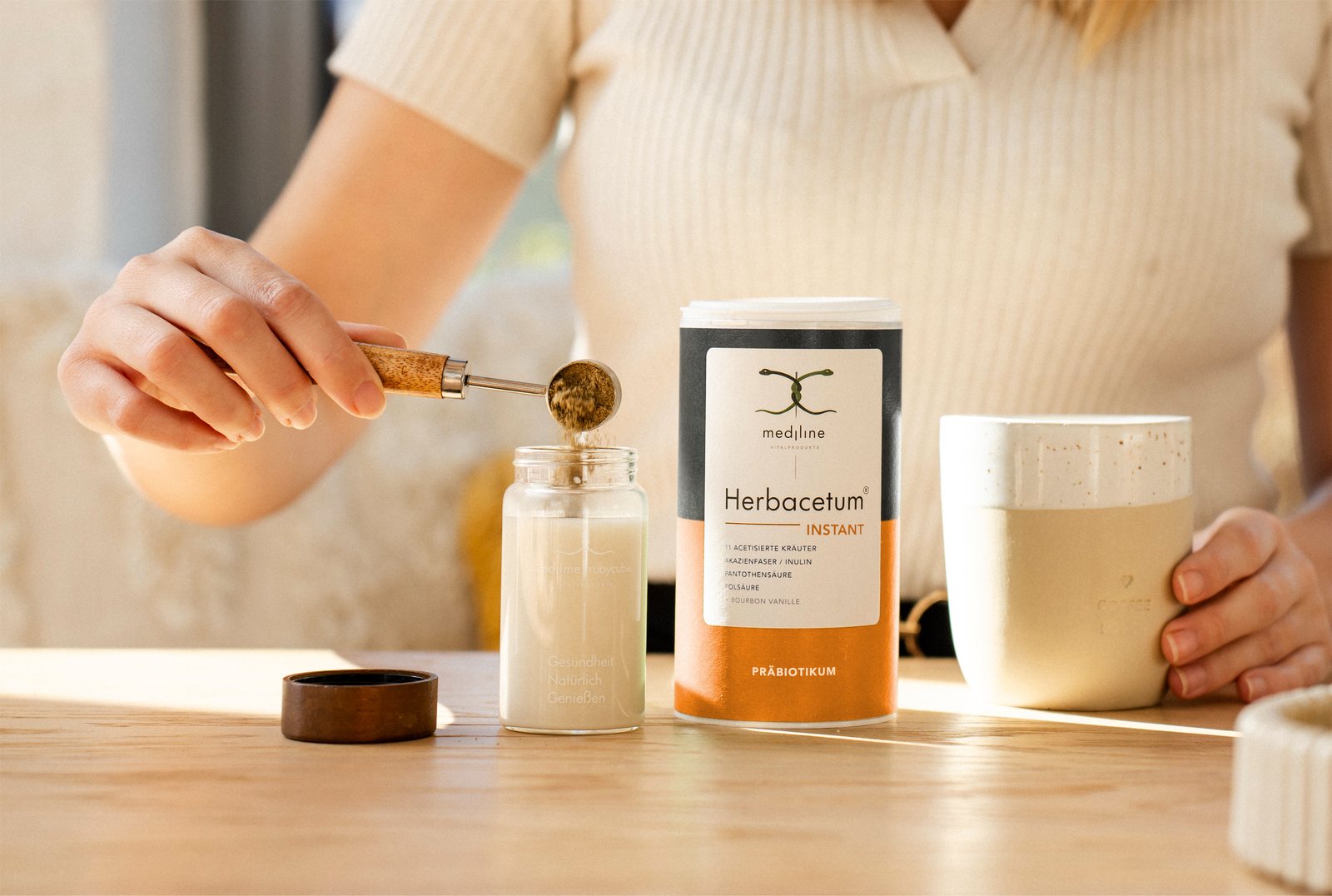 Herbacetum Instant Bourbon Vanille von Mediline, Instant-Pulver wird auf Holztisch zubereitet